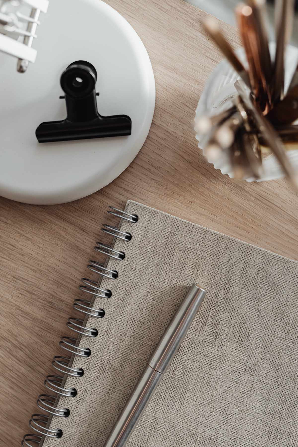 Closeup van een bureau met lamp, potje met schrijfgerief en schriftje